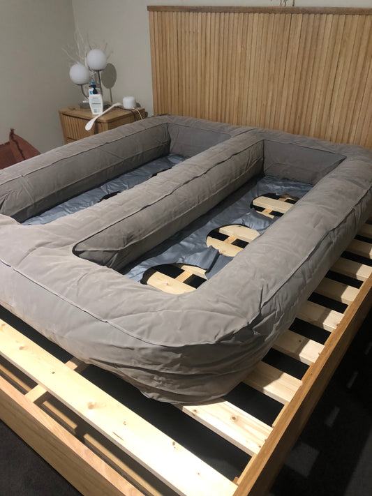 Bedezy mattress lifter inflated on a slat bed base without a mattress on top showing 3 air columns that lift the mattress. 